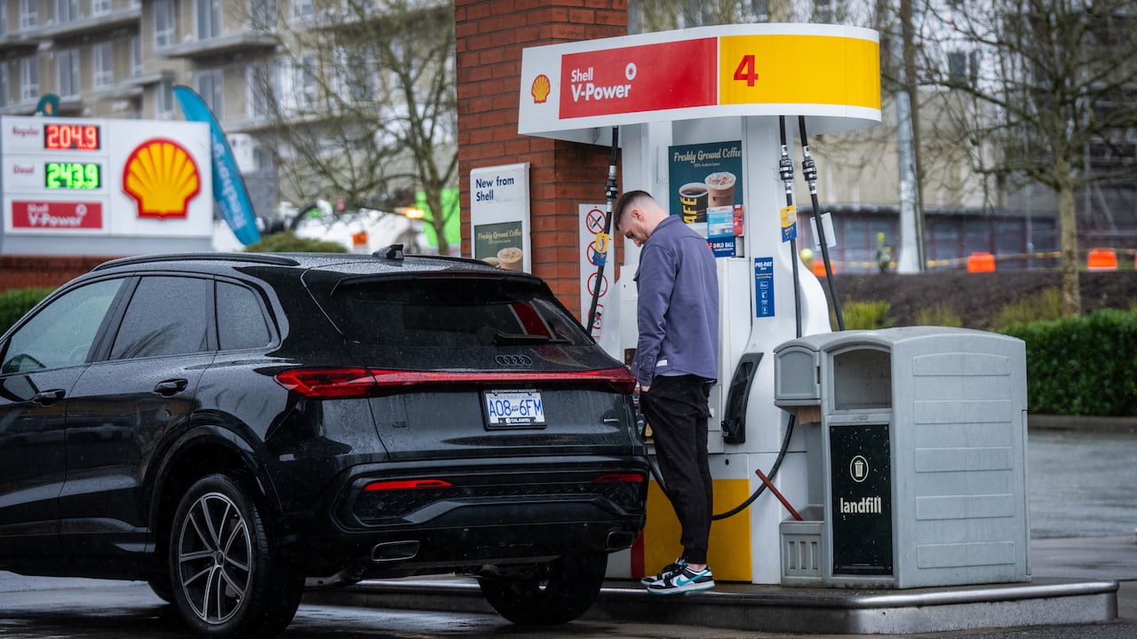 A man fills up gas in his car at a local gas station in Surrey, B.C.